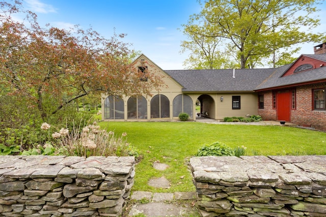18 Laurel Ln, Eliot, ME 03903 - view of front facade with a front yard, a sunroom, roof with shingles, and brick siding
