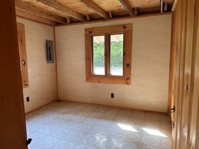 734 Duck Cove Rd, Roque Bluffs, ME 04654 - empty room with light flooring, beamed ceiling, baseboards, wooden ceiling, and electric panel