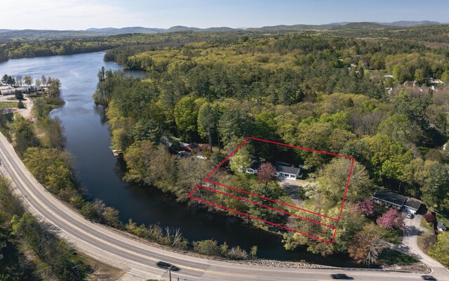 13 Packard Ave, Norway, ME 04268 - aerial overview of property's location with a heavily wooded area, a water and mountain view, and property parcel outlined