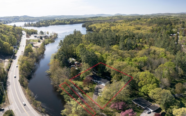 13 Packard Ave, Norway, ME 04268 - aerial overview of property's location with a heavily wooded area, a large body of water, and property parcel outlined