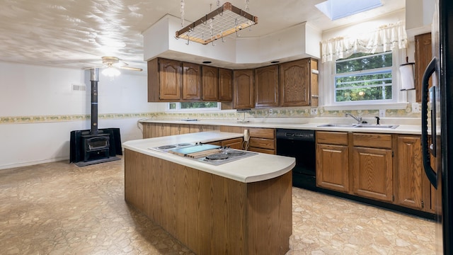 13 Packard Ave, Norway, ME 04268 - kitchen featuring black appliances, a kitchen island, light countertops, a wood stove, and brown cabinets