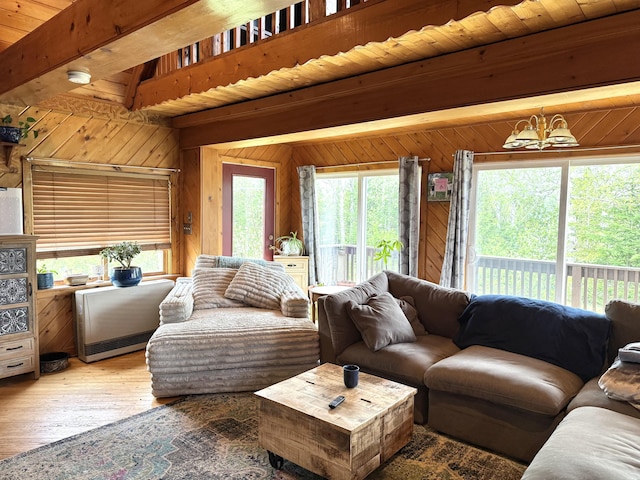 135 W Conroy Lake Rd, Monticello, ME 04760 - living room with wooden walls, beamed ceiling, a chandelier, and hardwood / wood-style floors
