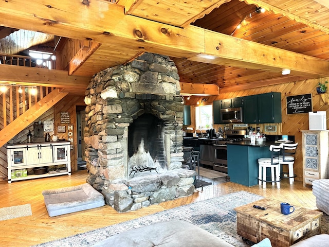 135 W Conroy Lake Rd, Monticello, ME 04760 - living room with wooden walls, light wood-style floors, wood ceiling, a fireplace, and stairway