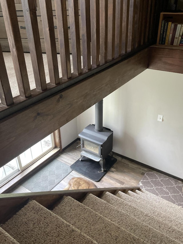 135 W Conroy Lake Rd, Monticello, ME 04760 - stairway with a wood stove, wood finished floors, and baseboards