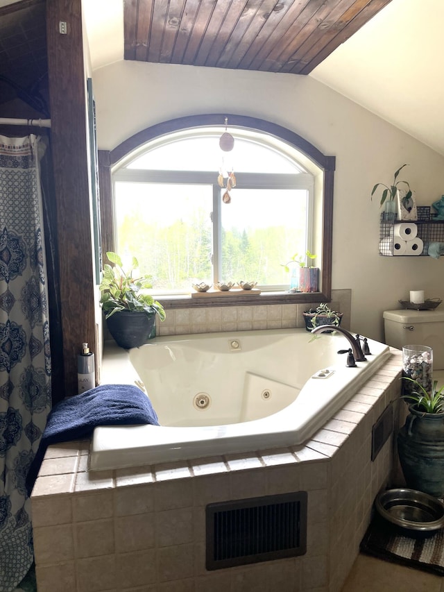 135 W Conroy Lake Rd, Monticello, ME 04760 - bathroom featuring vaulted ceiling, a tub with jets, and toilet