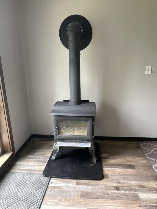 135 W Conroy Lake Rd, Monticello, ME 04760 - detailed view of a wood stove, wood finished floors, and baseboards