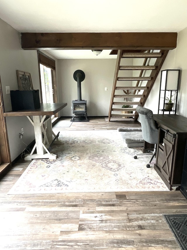 135 W Conroy Lake Rd, Monticello, ME 04760 - home office featuring wood finished floors, beam ceiling, and a wood stove