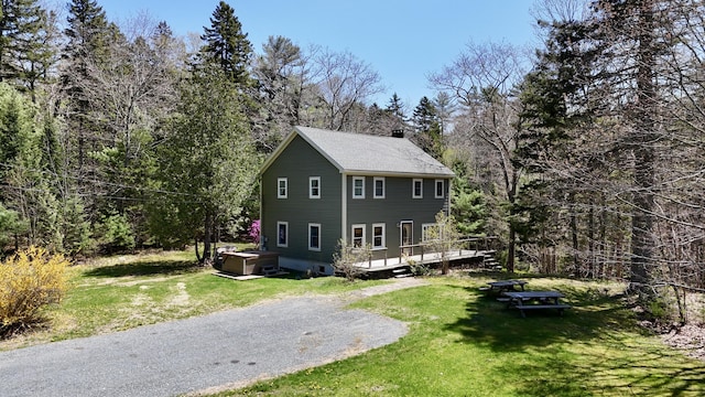 71 Snows Cove Rd, Sedgwick, ME 04676 - view of front of home with a front lawn, a chimney, a wooden deck, and a hot tub
