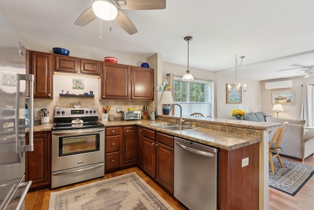 30 Agatha James Dr Unit 11, Kennebunk, ME 04043 - kitchen with appliances with stainless steel finishes, a sink, ceiling fan, open floor plan, and light wood-type flooring