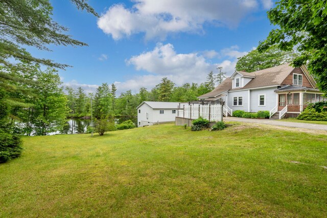 24 Emery Corner Rd, Limerick, ME 04048 - view of grassy yard with a sunroom and a deck with water view