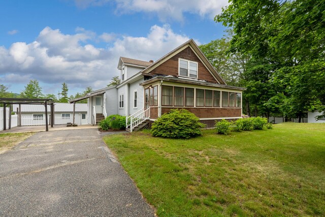 24 Emery Corner Rd, Limerick, ME 04048 - view of front of property with a sunroom, asphalt driveway, entry steps, and a front lawn