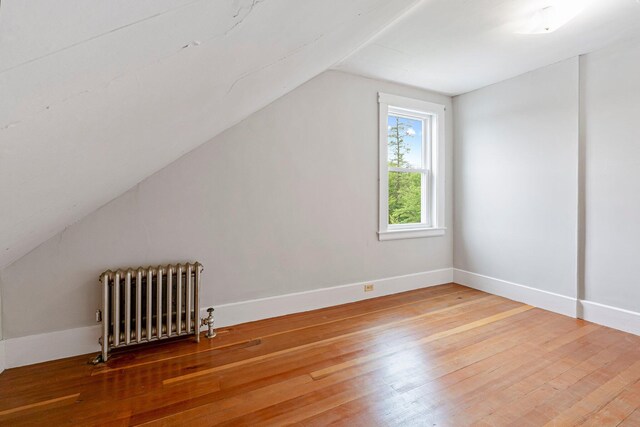 24 Emery Corner Rd, Limerick, ME 04048 - bonus room featuring radiator heating unit, lofted ceiling, and light wood-style floors