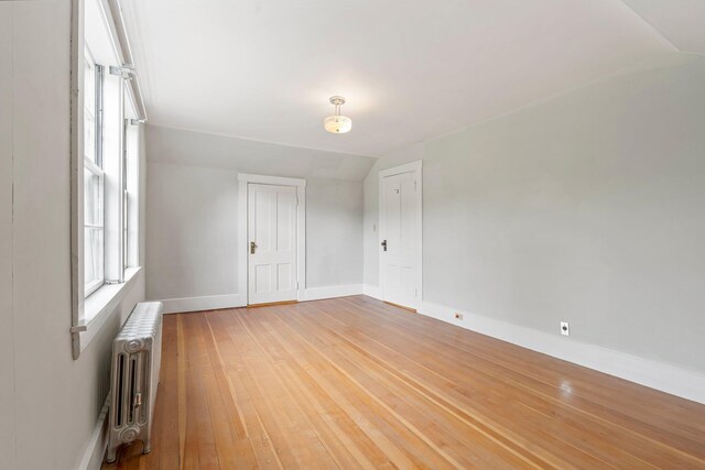 24 Emery Corner Rd, Limerick, ME 04048 - spare room with radiator heating unit, vaulted ceiling, and light wood-type flooring