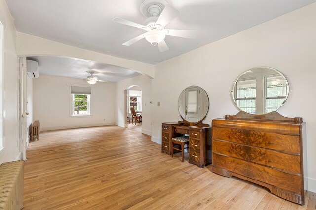 24 Emery Corner Rd, Limerick, ME 04048 - empty room with arched walkways, radiator, a ceiling fan, light wood-style floors, and a wall unit AC