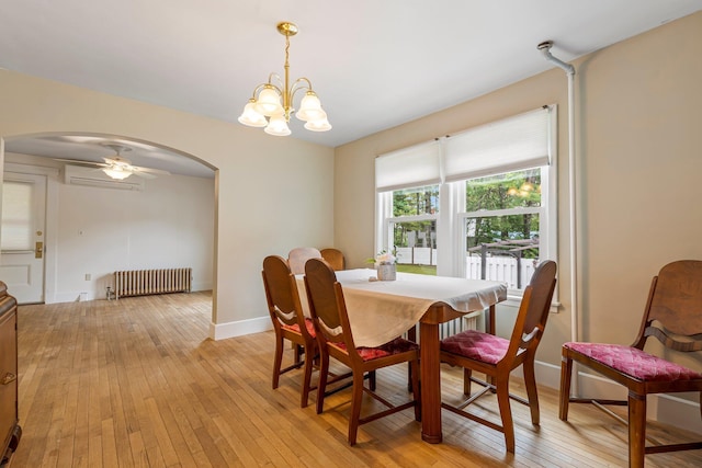 24 Emery Corner Rd, Limerick, ME 04048 - dining room featuring arched walkways, radiator, light wood-type flooring, a chandelier, and a wall unit AC