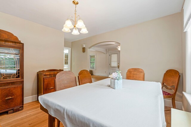 24 Emery Corner Rd, Limerick, ME 04048 - dining area with arched walkways, light wood-style floors, and a chandelier