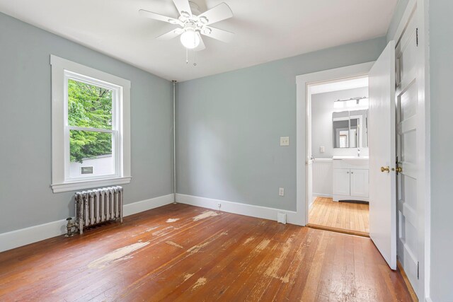24 Emery Corner Rd, Limerick, ME 04048 - unfurnished bedroom featuring radiator heating unit, wood-type flooring, and connected bathroom