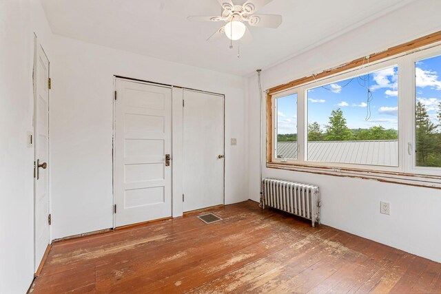 24 Emery Corner Rd, Limerick, ME 04048 - unfurnished bedroom featuring radiator, wood-type flooring, multiple windows, and a closet