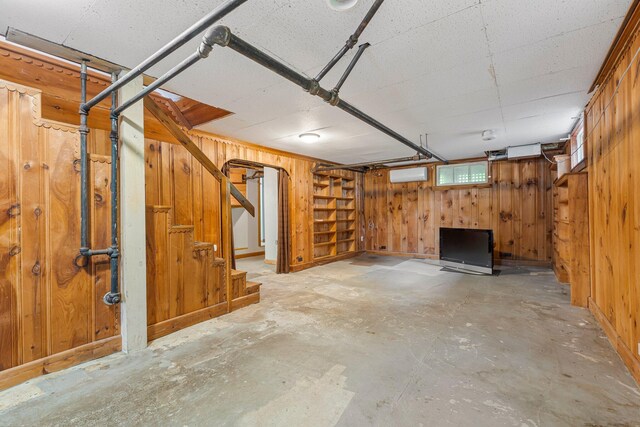 24 Emery Corner Rd, Limerick, ME 04048 - below grade area featuring wood walls, a wall mounted air conditioner, and stairway