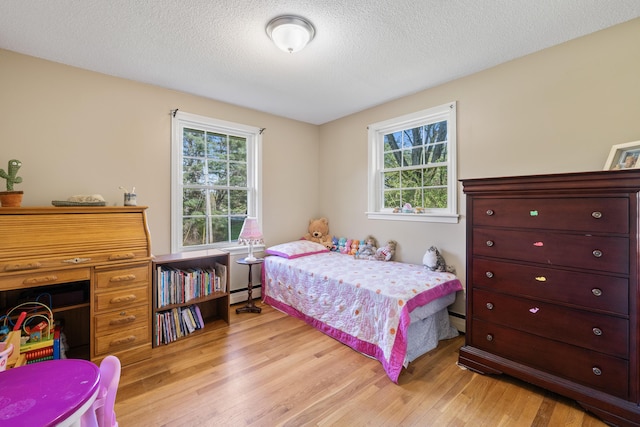 20 Sunderland Dr, Auburn, ME 04210 - bedroom featuring a baseboard heating unit, light wood finished floors, and a textured ceiling