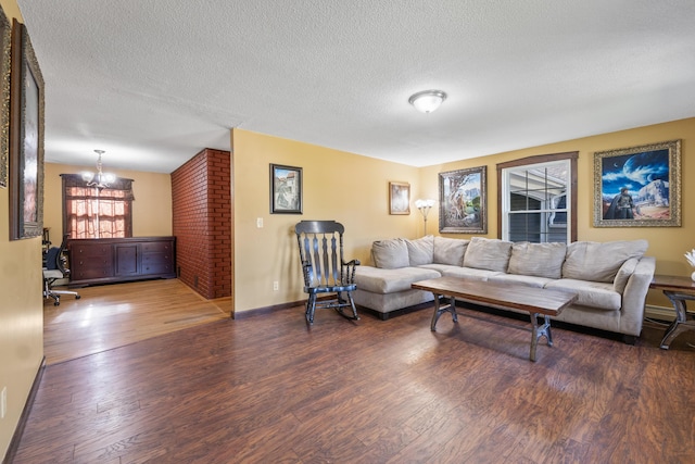 20 Sunderland Dr, Auburn, ME 04210 - living room featuring a chandelier, wood finished floors, a textured ceiling, baseboard heating, and baseboards