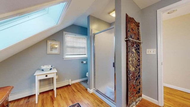 72 Sand Beach Rd, Standish, ME 04084 - bathroom featuring a stall shower, wood finished floors, lofted ceiling, toilet, and a skylight