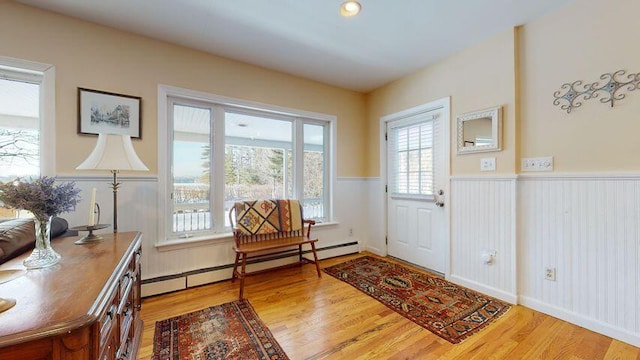 72 Sand Beach Rd, Standish, ME 04084 - foyer entrance with a baseboard radiator, light wood-style floors, and wainscoting