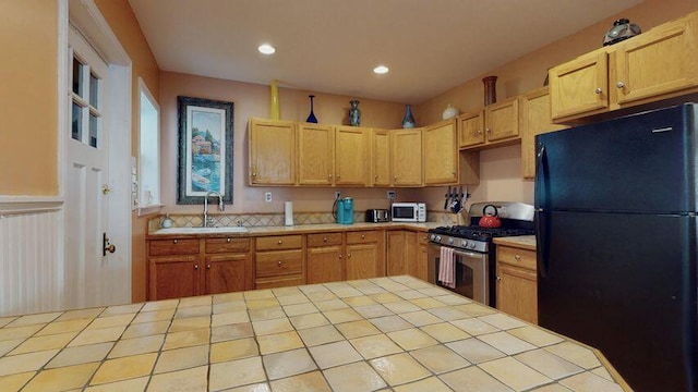 72 Sand Beach Rd, Standish, ME 04084 - kitchen with freestanding refrigerator, stainless steel gas range oven, a sink, tile counters, and recessed lighting