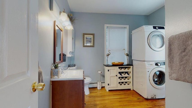 72 Sand Beach Rd, Standish, ME 04084 - laundry room with estacked washer and dryer, baseboard heating, and light wood-style floors