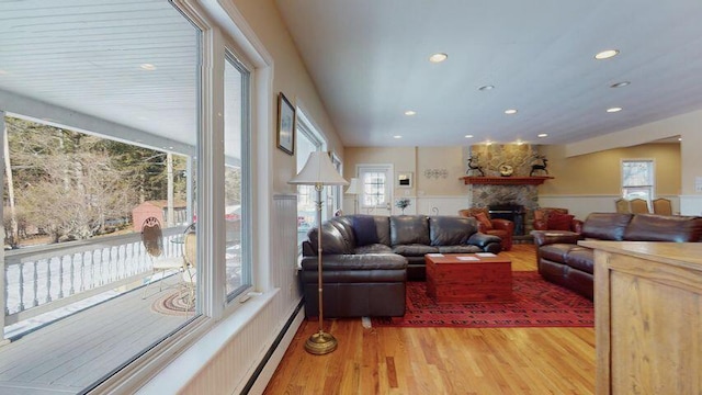 72 Sand Beach Rd, Standish, ME 04084 - living room featuring baseboard heating, recessed lighting, light wood finished floors, and a stone fireplace