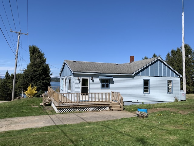11 Brewster Rd, Eastport, ME 04631 - back of property with roof with shingles, a wooden deck, a yard, a chimney, and board and batten siding