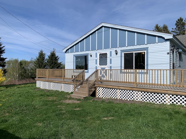 11 Brewster Rd, Eastport, ME 04631 - back of property with board and batten siding, a wooden deck, and a yard