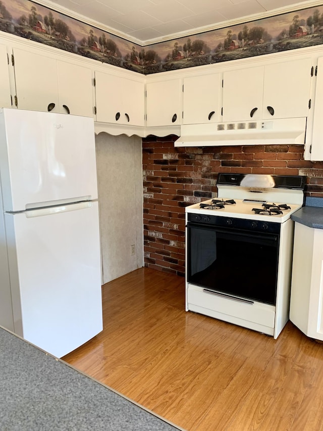 11 Brewster Rd, Eastport, ME 04631 - kitchen featuring freestanding refrigerator, range with gas stovetop, under cabinet range hood, light wood finished floors, and white cabinets