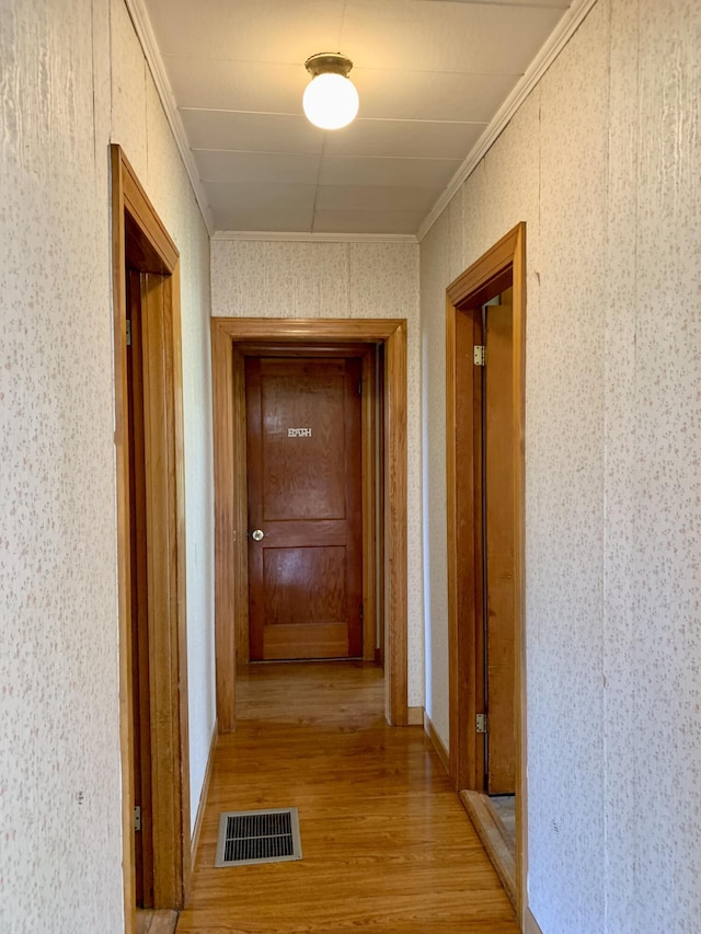 11 Brewster Rd, Eastport, ME 04631 - hallway featuring light wood-style flooring, wallpapered walls, and ornamental molding