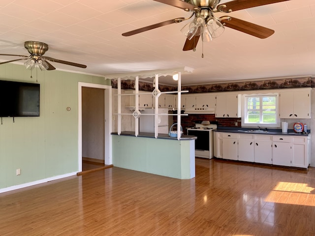 11 Brewster Rd, Eastport, ME 04631 - kitchen featuring electric stove, dark countertops, a ceiling fan, white cabinets, and crown molding