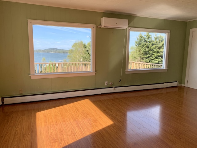 11 Brewster Rd, Eastport, ME 04631 - empty room featuring a wall unit AC, crown molding, wood finished floors, plenty of natural light, and a water view