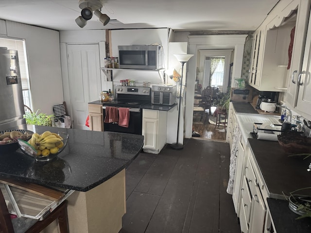 29 Fish Point Rd, Orland, ME 04472 - kitchen with stainless steel appliances, white cabinets, a kitchen bar, dark wood-style floors, and a sink