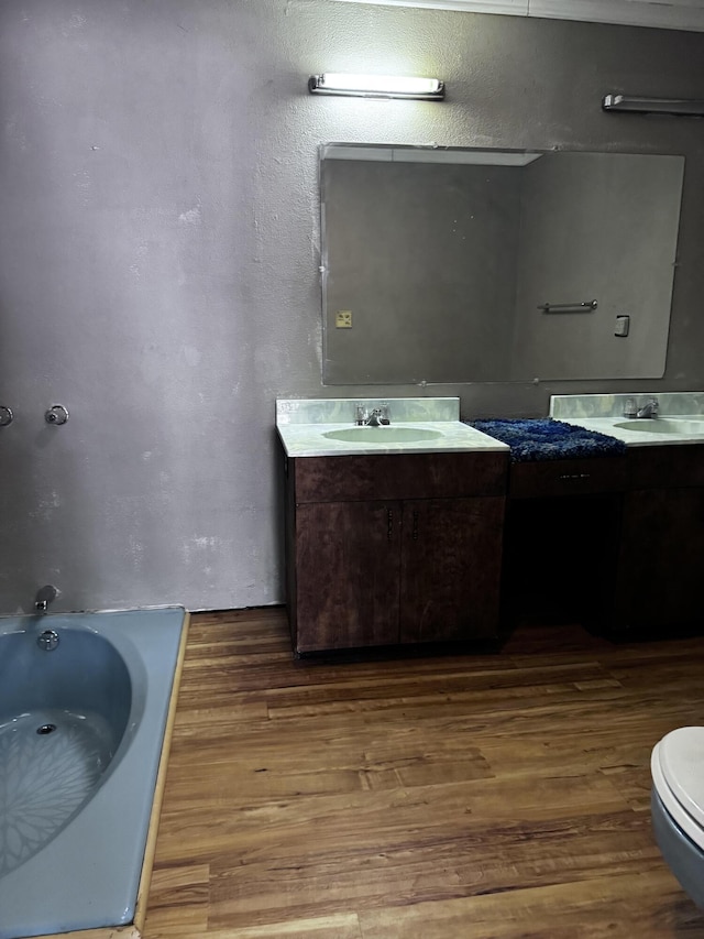1596 Bald Mountain Rd, Orland, ME 04472 - full bathroom with wood finished floors, a tub to relax in, vanity, and toilet