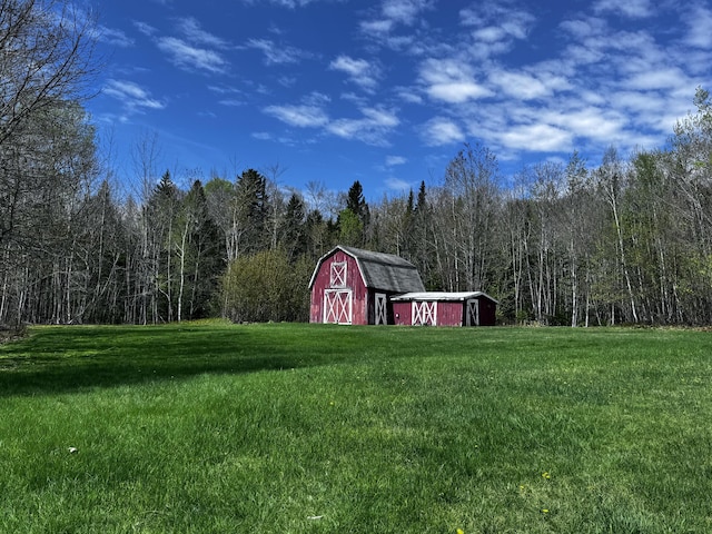 1596 Bald Mountain Rd, Orland, ME 04472 - view of green lawn with an outbuilding, a barn, and a forest view