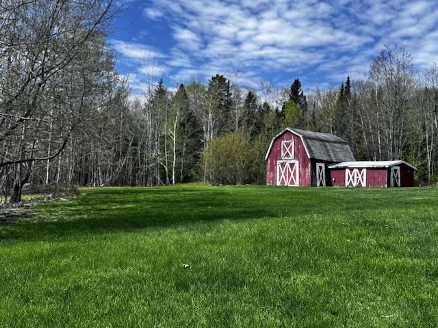 1596 Bald Mountain Rd, Orland, ME 04472 - view of green lawn featuring an outbuilding, a barn, and a wooded view