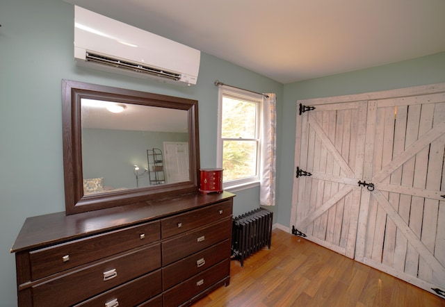 51 Brookview Dr, Bucksport, ME 04416 - bedroom featuring radiator heating unit, a wall unit AC, and light wood finished floors