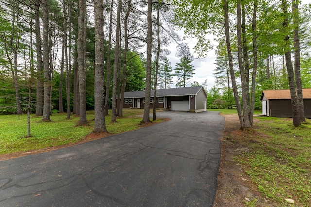 55 Woodland St, Fryeburg, ME 04037 - single story home with an outbuilding, asphalt driveway, an attached garage, and a front yard