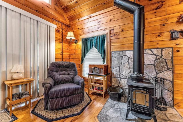 19 Birch Ests, Rome, ME 04963 - sitting room featuring a wood stove, lofted ceiling, hardwood / wood-style floors, and wood walls
