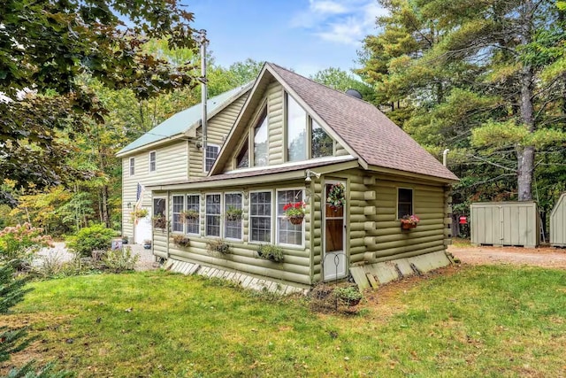 19 Birch Ests, Rome, ME 04963 - view of front of home with a storage unit, an outdoor structure, log siding, and a front lawn