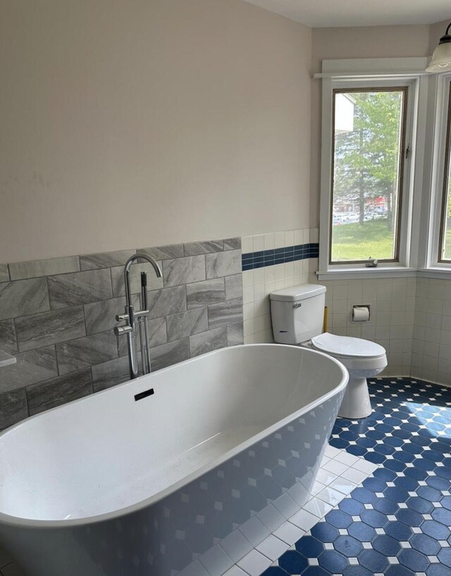 30 Elm St, Fort Kent, ME 04743 - full bath with a soaking tub, toilet, tile walls, tile patterned floors, and wainscoting