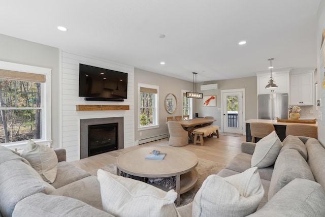 6 Roberts Ln, Kennebunkport, ME 04046 - living room featuring a baseboard radiator, a wall mounted air conditioner, recessed lighting, light wood-style floors, and a fireplace