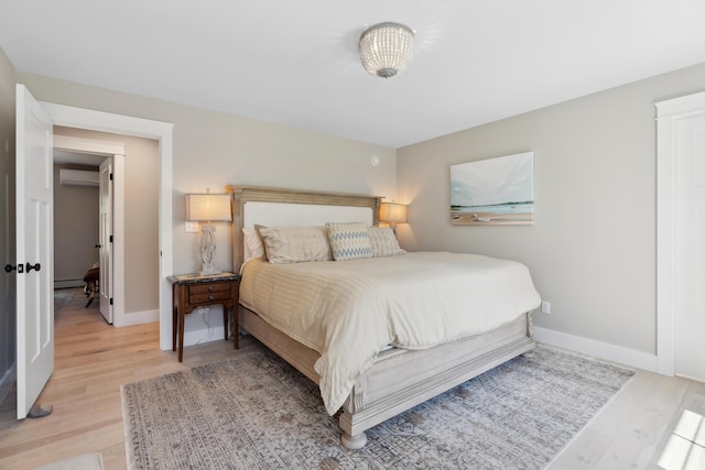 6 Roberts Ln, Kennebunkport, ME 04046 - bedroom with light wood finished floors, a wall mounted AC, a baseboard radiator, and baseboards