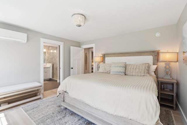 6 Roberts Ln, Kennebunkport, ME 04046 - bedroom with a wall mounted air conditioner, wood finished floors, baseboards, and ensuite bath