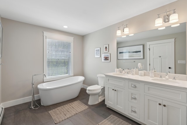 6 Roberts Ln, Kennebunkport, ME 04046 - bathroom with baseboards, a soaking tub, double vanity, recessed lighting, and toilet