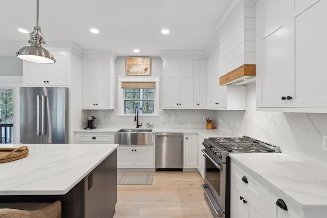 6 Roberts Ln, Kennebunkport, ME 04046 - kitchen featuring appliances with stainless steel finishes, a sink, light wood finished floors, white cabinetry, and pendant lighting
